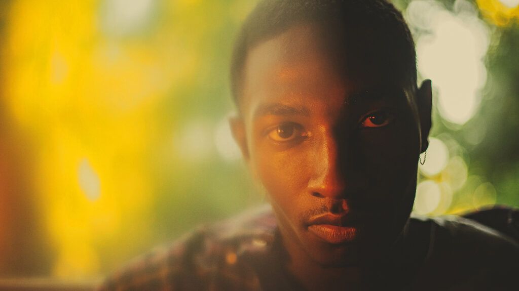 Young man's face against blurred abstract background